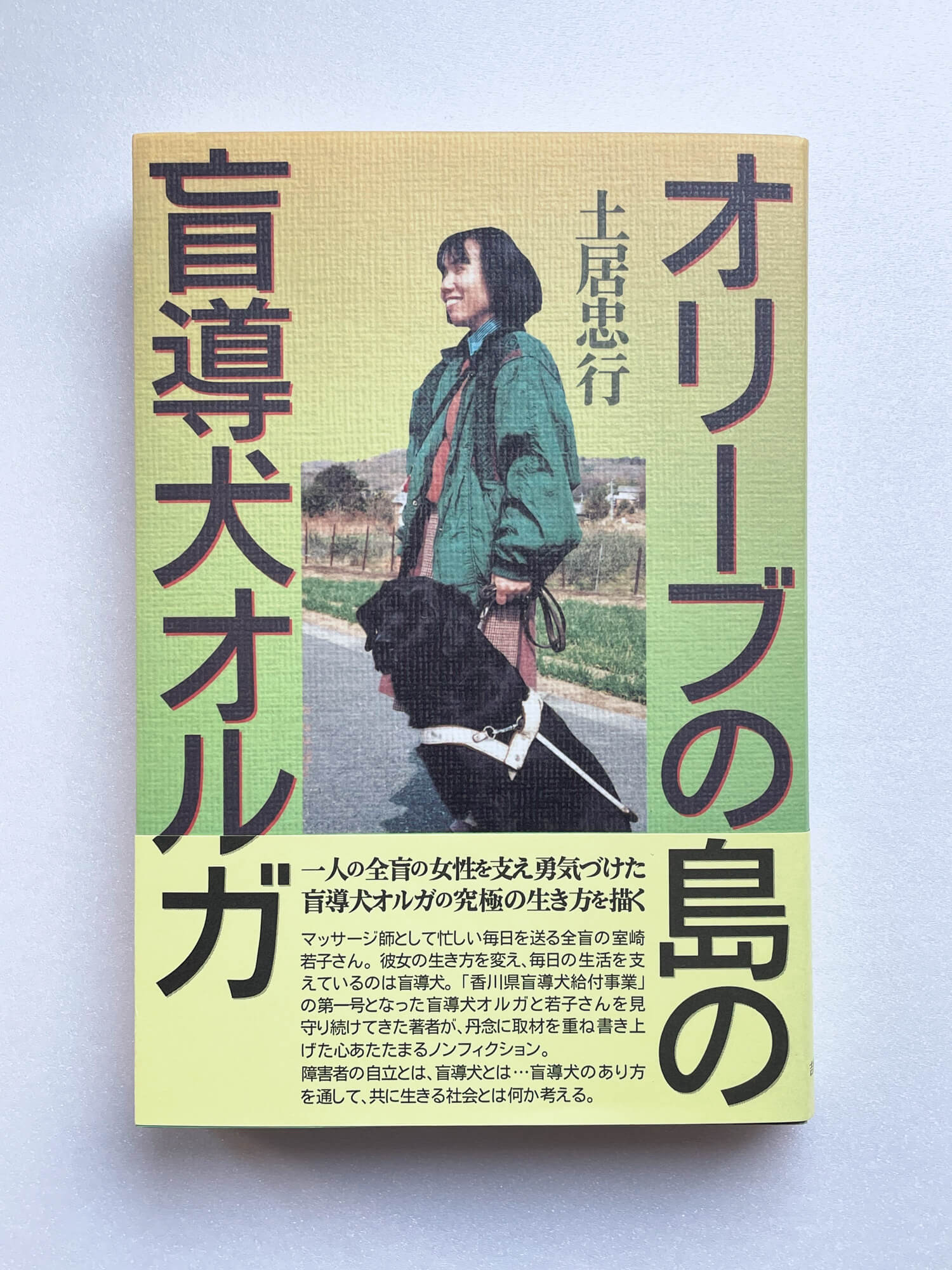 『オリーブの島の盲導犬オルガ』（土居忠行）。裏表紙の EYE LOVE EYEマークは 視覚障害のために非営利の目的で点訳、朗読、拡大することを認めたもの。